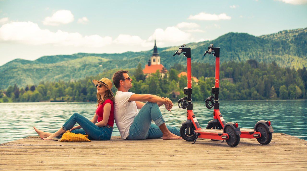 Couple enjoying a local outing on their eco-friendly e-scooters provided by their vacation rental.